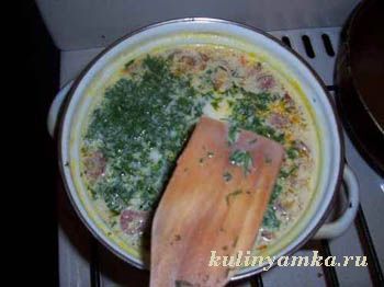 Готовый сырный суп в тарелке с зеленью